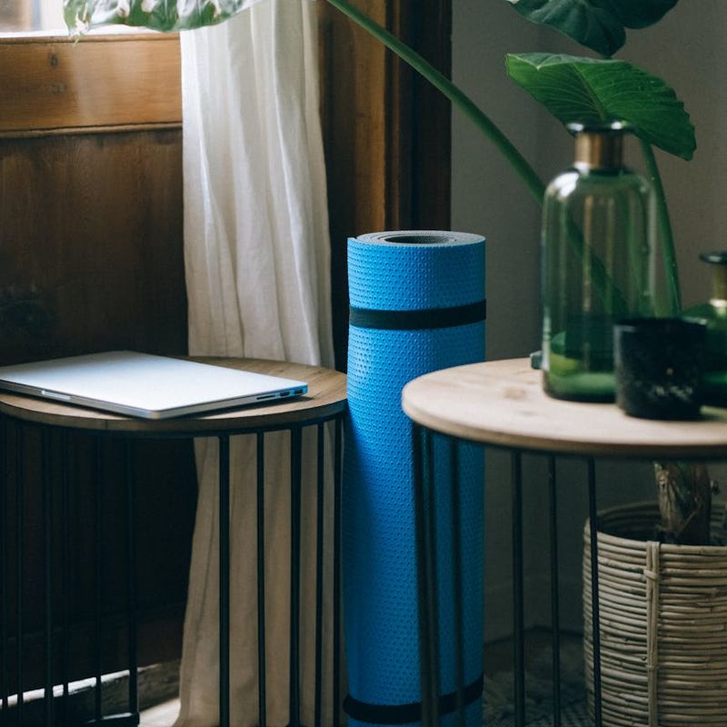 A bright, minimalist room with a yoga mat on the wooden floor.